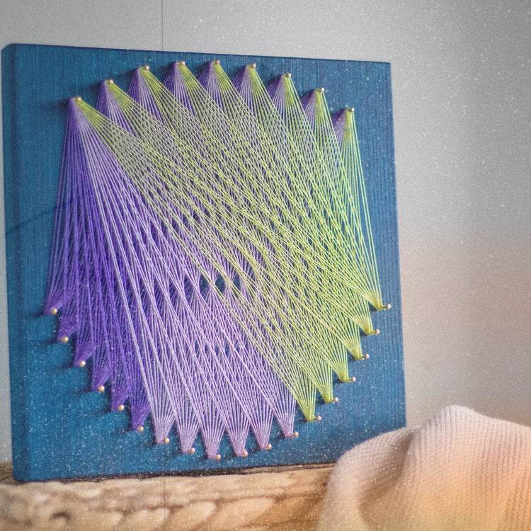 geometric string art sign on blue wood base