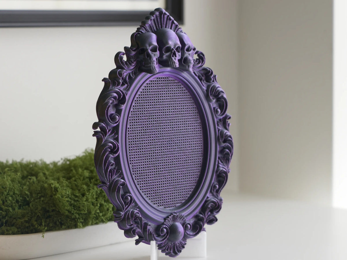 Purple 3D printed skull frame with an oval stitchable grid, leaning on a white shelf