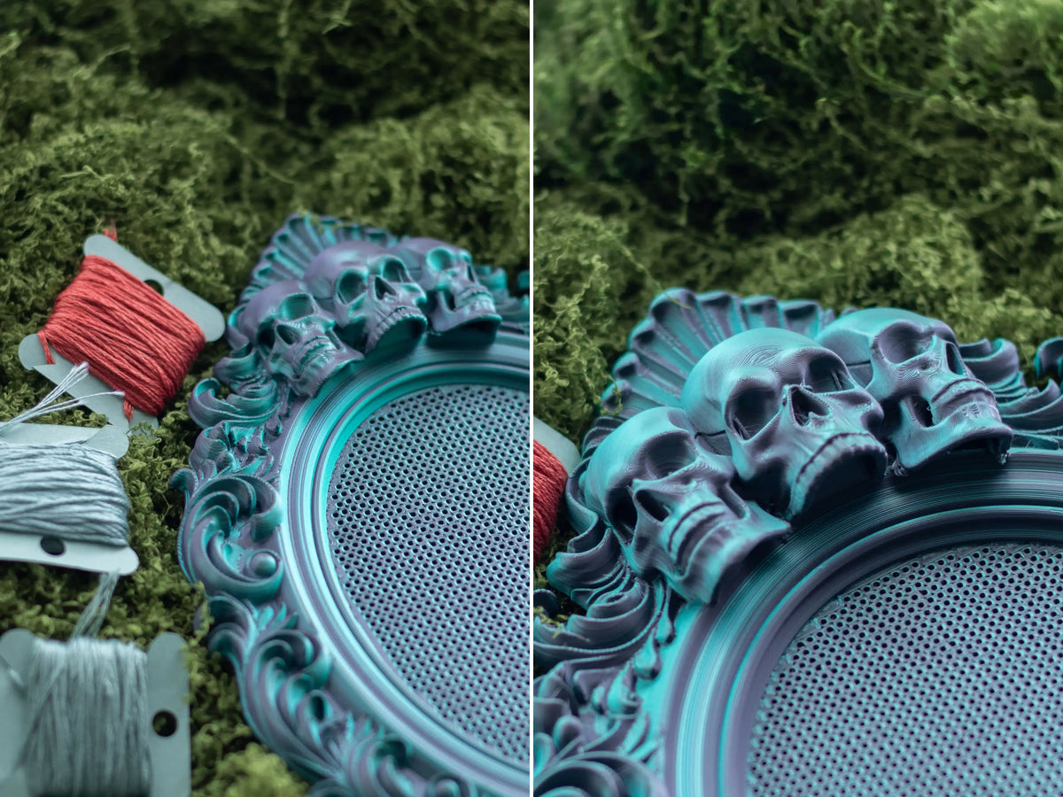 Close-up of the teal skull frame's perforated stitching grid next to embroidery floss on moss