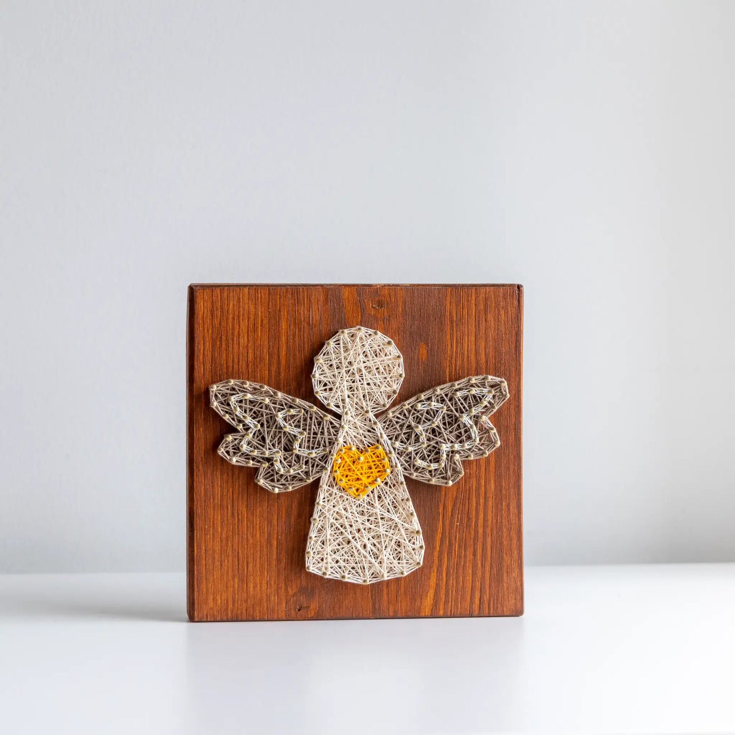 Wooden wood board with string art angel on a white background