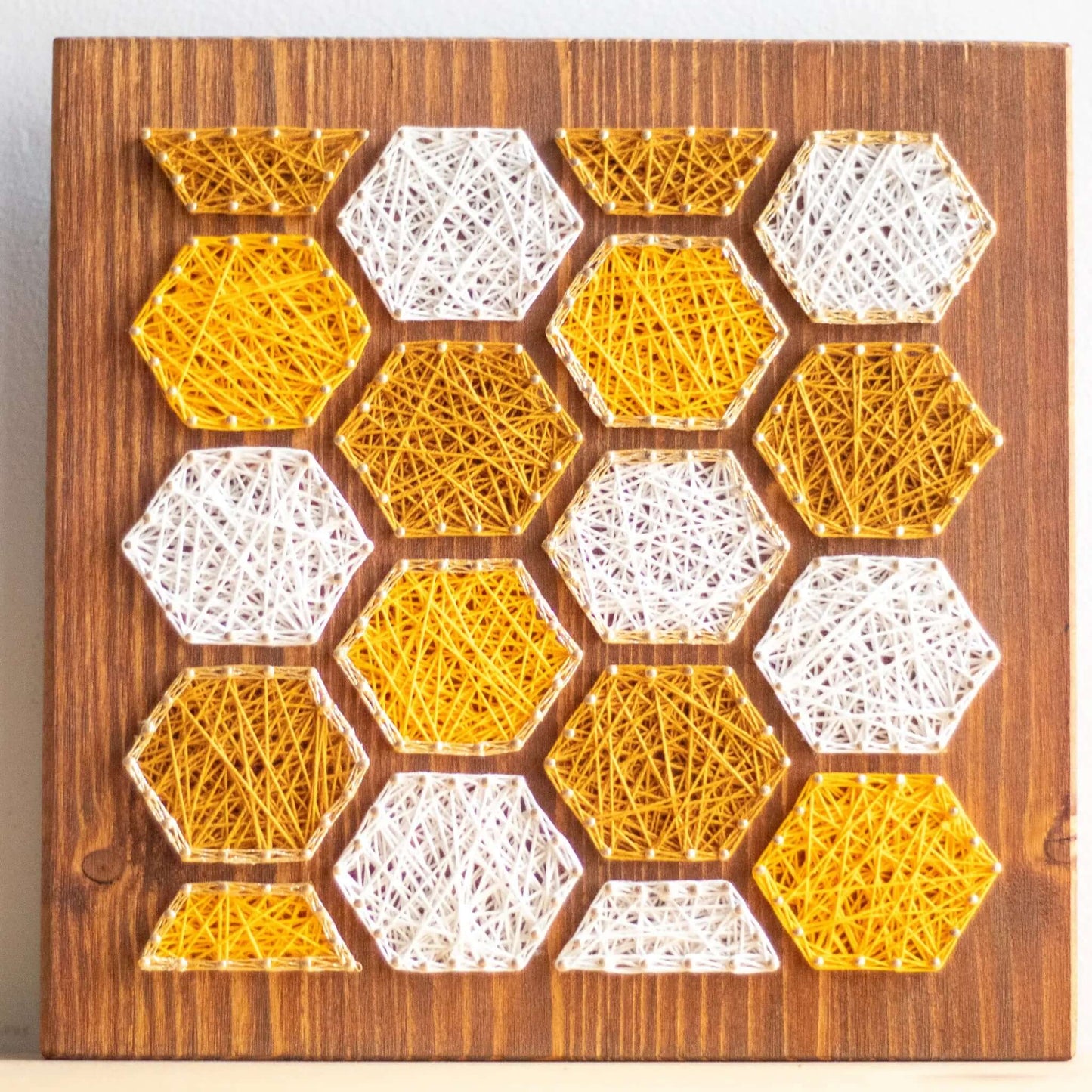 bee honeycombs string art sign on a wooden board made gold color nails and warm tone strings 