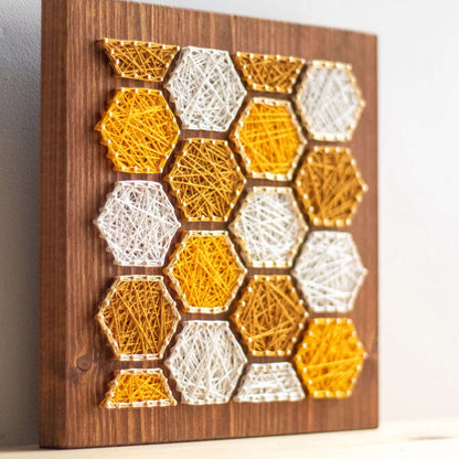 bee honeycombs string art sign on a wooden board made gold color nails and warm tone strings 