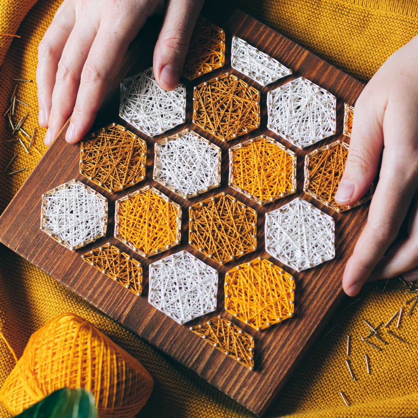 Bee honeycombs string art pattern featuring hexagonal designs in yellow and white thread on a wooden base. Available as a digital download for crafting enthusiasts.