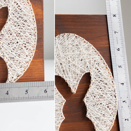 bunny silhouette string art sign made with gold color nails on a brown wood base