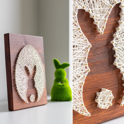 bunny silhouette string art sign made with gold color nails on a brown wood base