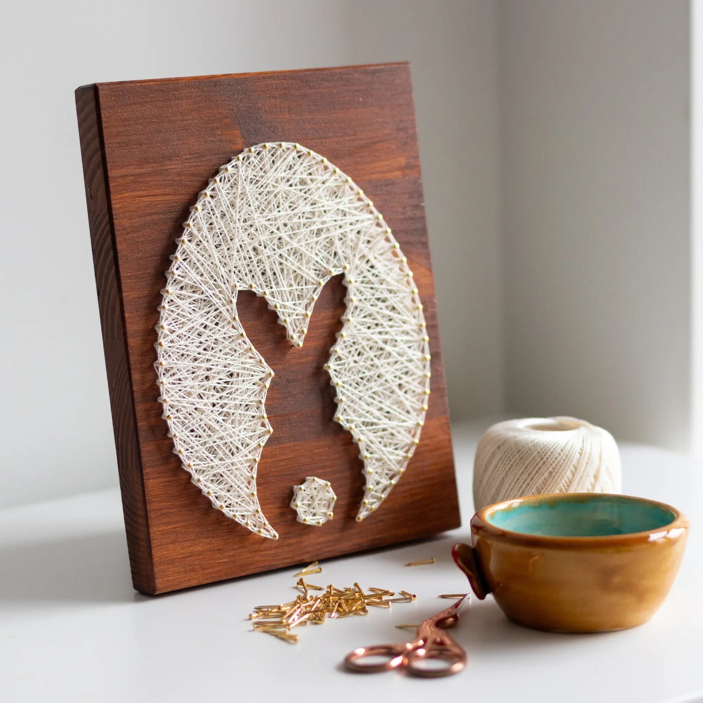 bunny silhouette string art sign made with gold color nails on a brown wood base