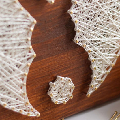 Close-up view of the bunny tail string art showing intricate nail and yarn work on the wooden board.