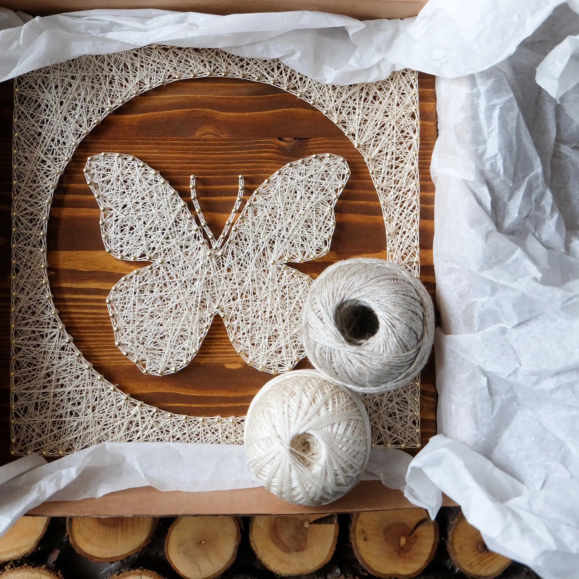 DIY butterfly string art kit in packaging, includes wooden base and white string, perfect craft project for adults.