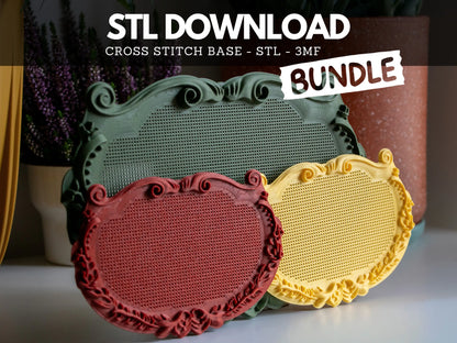 A large sage green and two small red and yellow ornate plaque cross stitch frames, 3D printed from the STL bundle, showing blank perforated stitching grids and scrollwork borders beside purple heather.