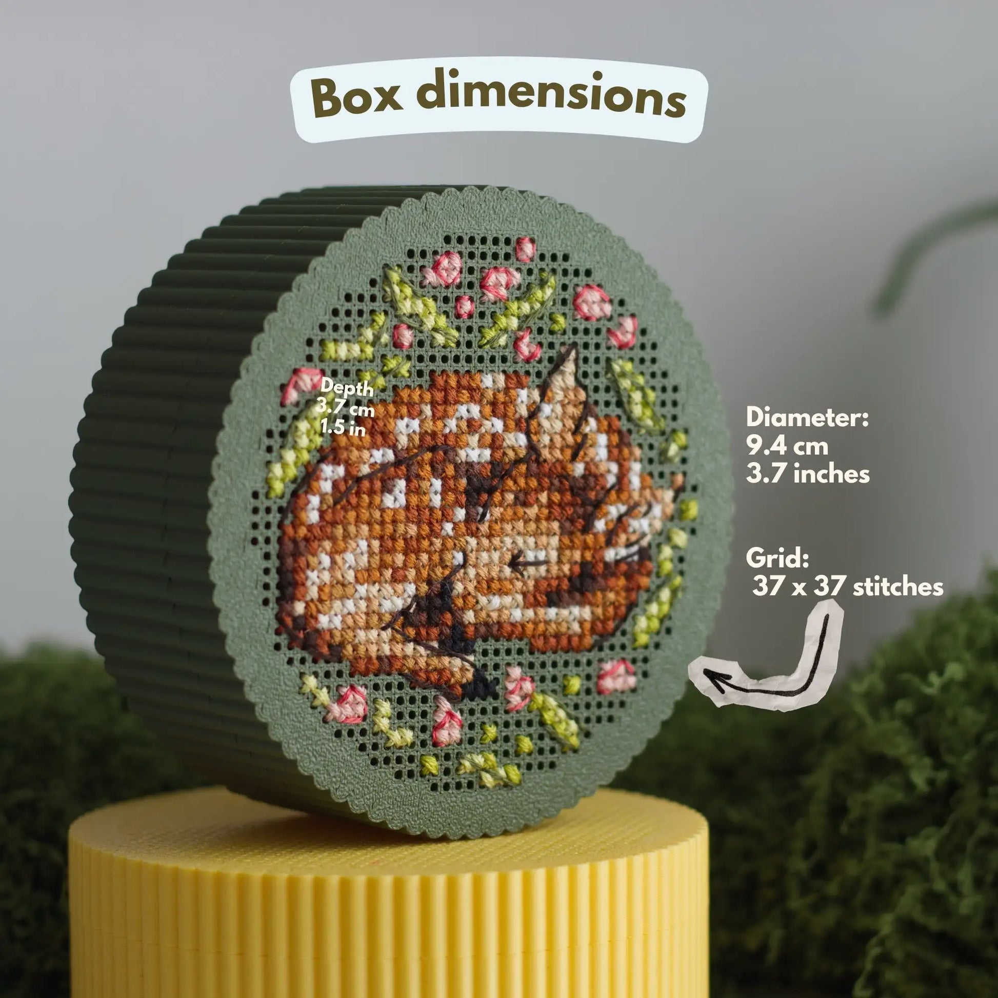 Round cross stitch box dimensions diagram — 9.4 cm (3.7 in) diameter, 3.7 cm (1.5 in) depth, 37 × 37 stitch grid, with finished sleeping fawn embroidery on dark green perforated lid