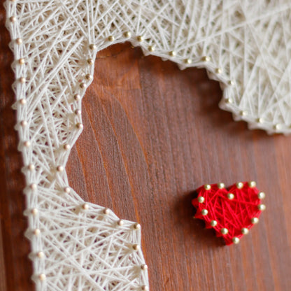 Close up view. Completed dog silhouette with heart string art design on a wooden board, crafted using GoodStrings' beginner-friendly string art pattern. Features a white thread outline of a dog with a heart detail, perfect for DIY home decor.