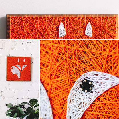 Handcrafted fox string art on a wooden board, featuring vibrant orange and white threads forming a fox face.