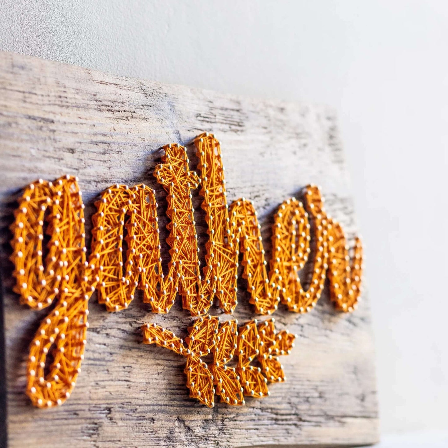 Close-up on the detailed string work in the fall 'Gather' sign pattern, featuring yellow string in a harvest-inspired design. A great addition for cozy autumn decor and DIY enthusiasts.