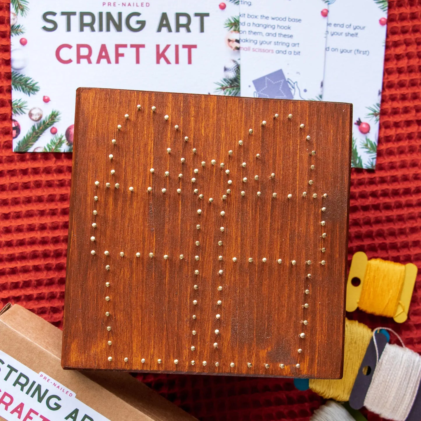Wood base pre-nailed for gift box string art pattern, showing nail placement for digital template.