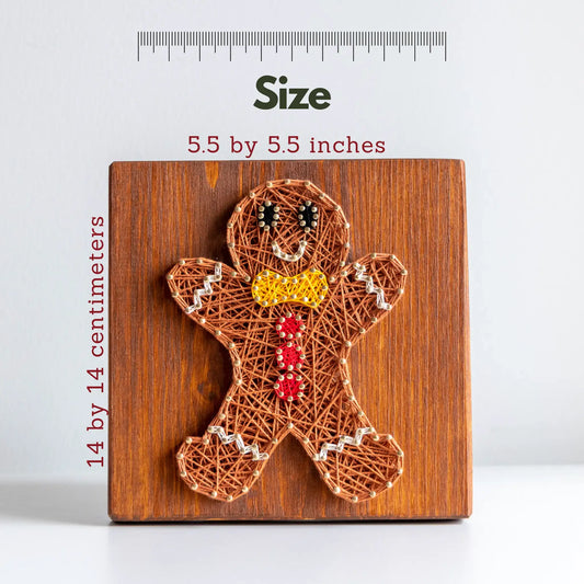 String art gingerbread man on a wooden board with measurements shown