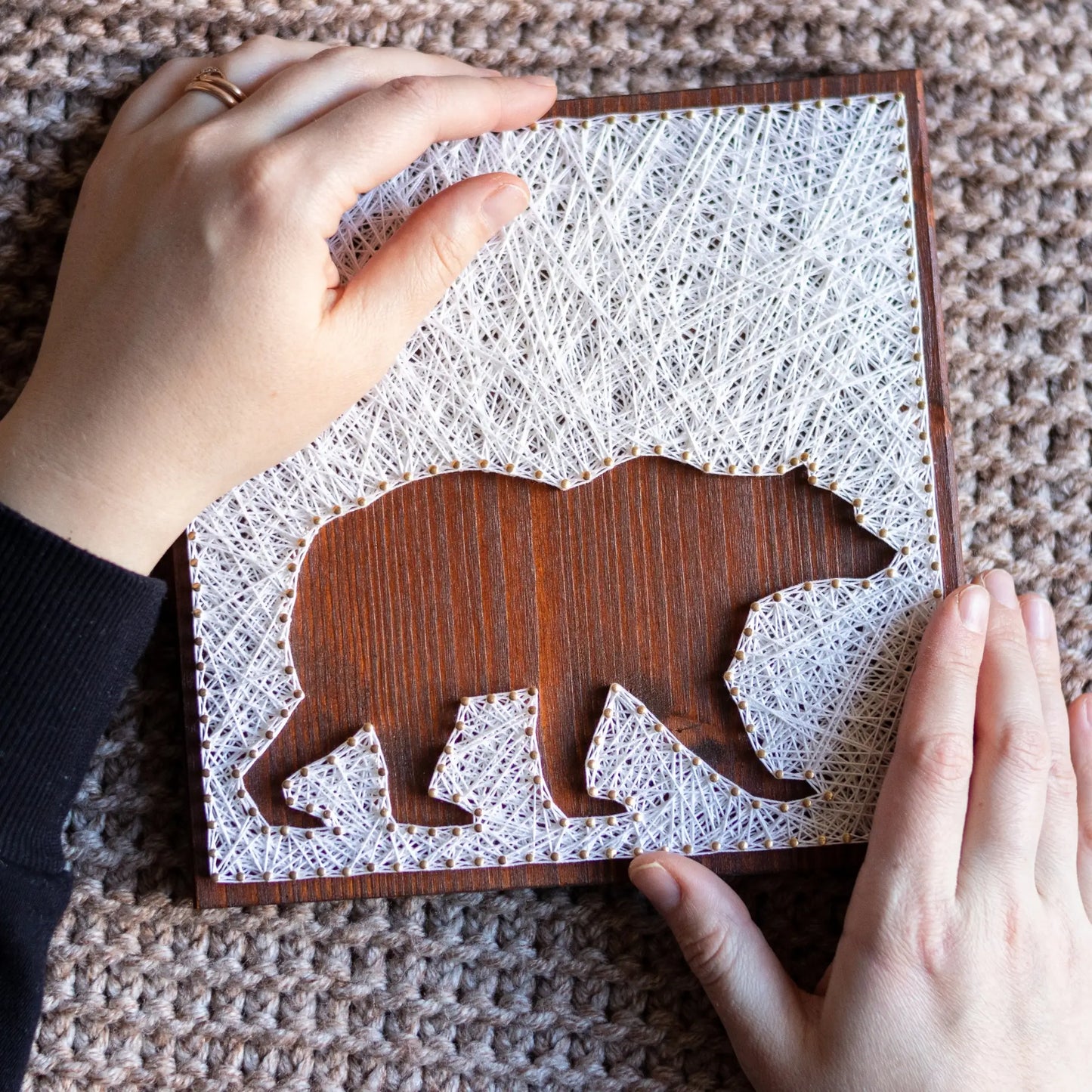 DIY string art kit featuring a bear silhouette with white threads on a dark wooden board by GoodStrings