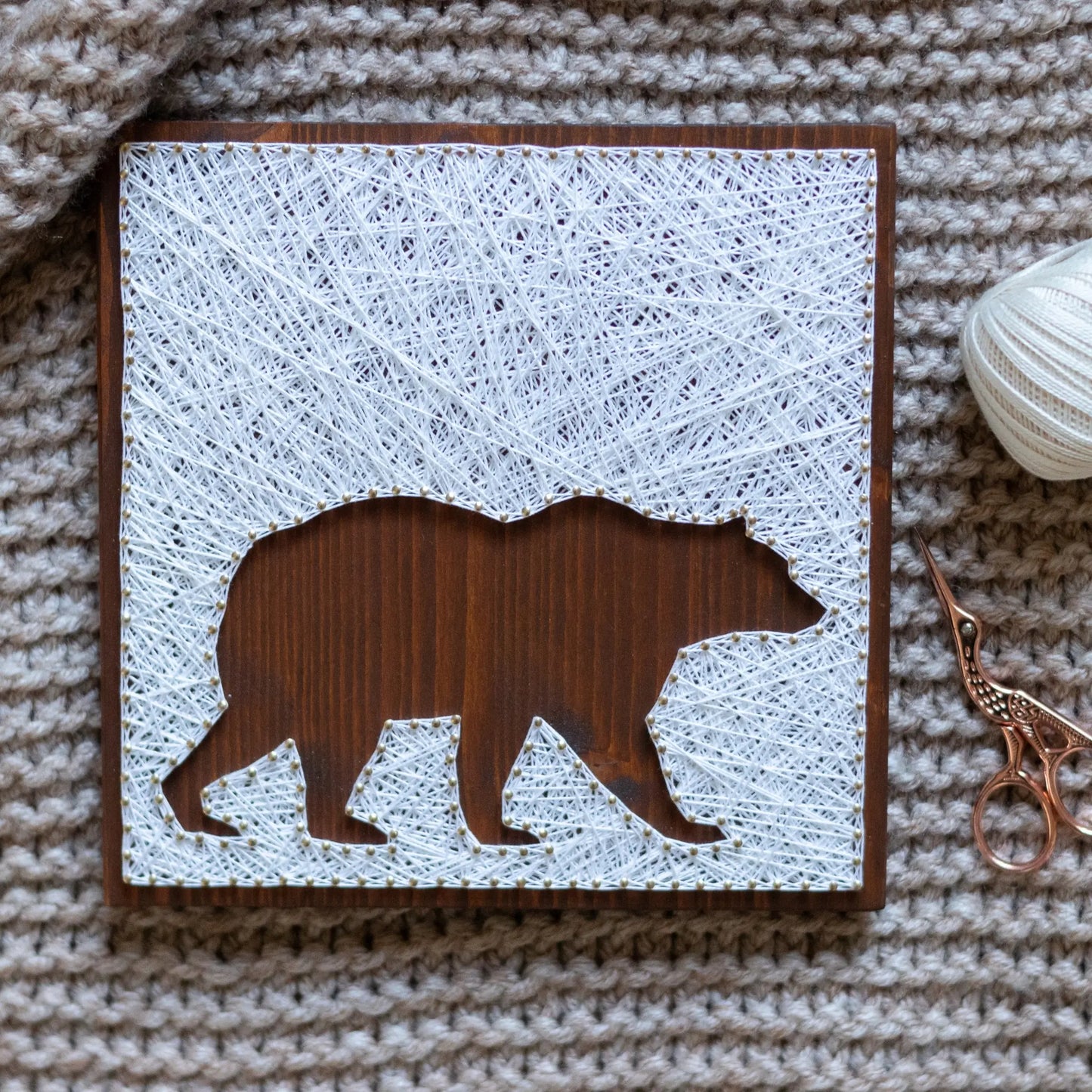 DIY string art kit featuring a bear silhouette with white threads on a dark wooden board by GoodStrings