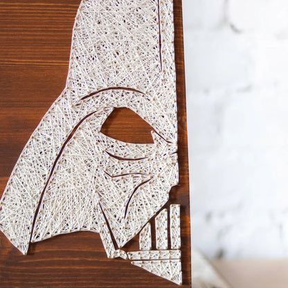 DIY string art kit featuring a silhouette of Darth Vader outlined with white thread on a rustic wooden board by GoodStrings - front zoomed in