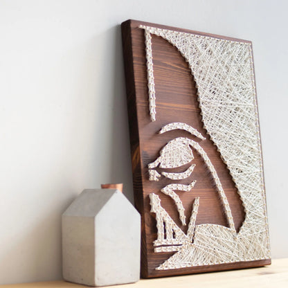 DIY string art kit featuring a silhouette of Darth Vader outlined with white thread on a rustic wooden board by GoodStrings - side view