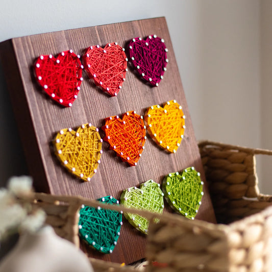 DIY string art kit with colorful hearts side on a rustic wooden board by GoodStrings - side view