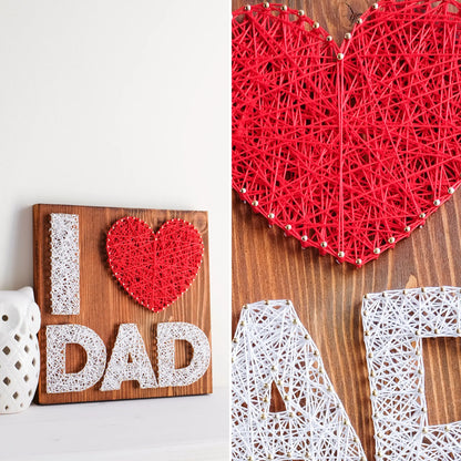 A heartfelt "I Love Dad" string art sign made with white and red string on a dark wooden background, featuring the words "I ♥ Dad" with a red heart.