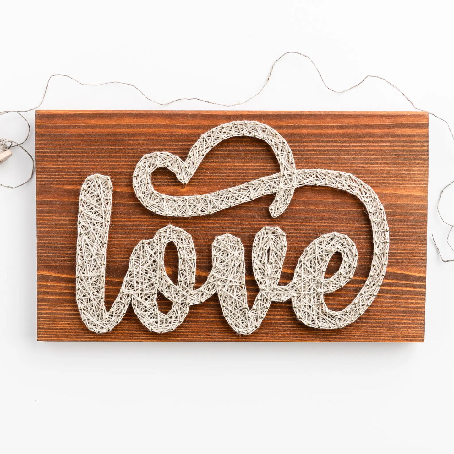 DIY string art kit spelling 'love' on a rustic wooden board by GoodStrings