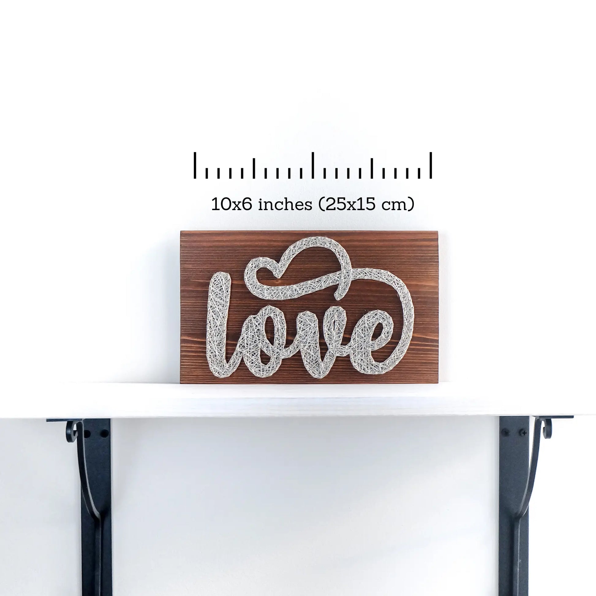 DIY string art kit spelling 'love' on a rustic wooden board by GoodStrings