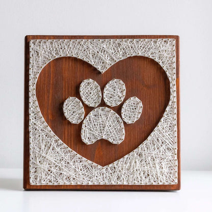 dog paw in a heart string art craft kit on a brown wood base made with gold color nails