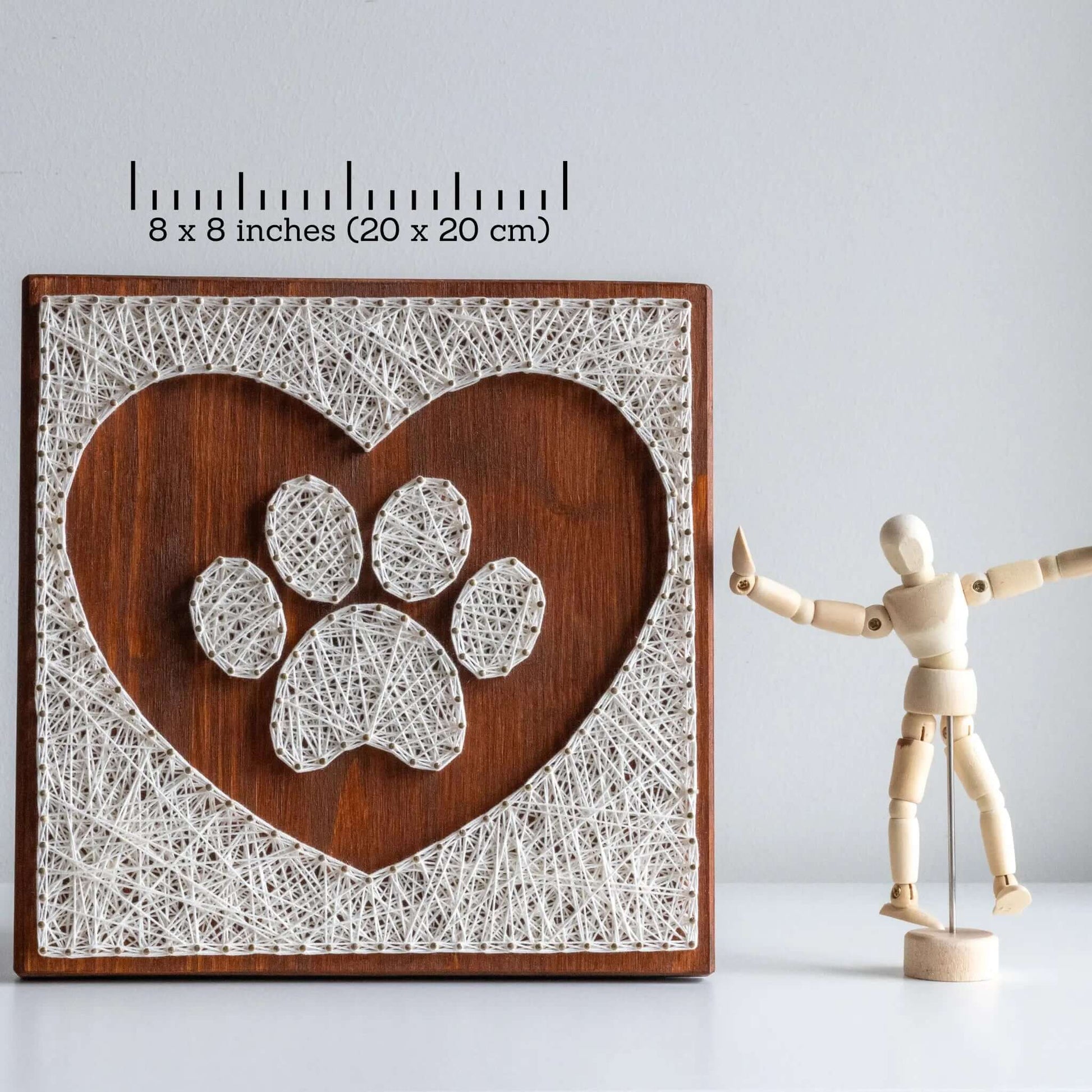 dog paw in a heart string art craft kit on a brown wood base made with gold color nails