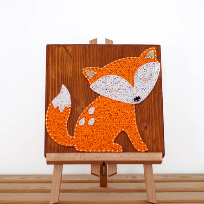 DIY string art kit featuring a cute fox silhouette with orange and white threads on a rustic wooden board by GoodStrings - white background