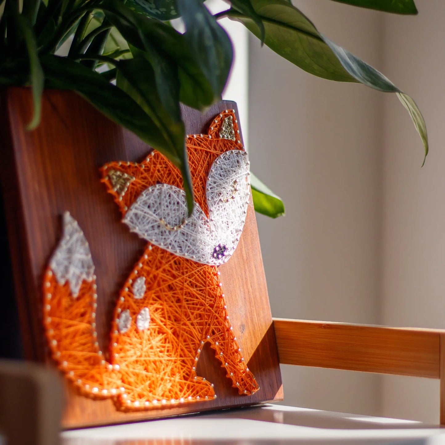 DIY string art kit featuring a cute fox silhouette with orange and white threads on a rustic wooden board by GoodStrings - left side view