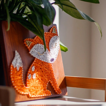 DIY string art kit featuring a cute fox silhouette with orange and white threads on a rustic wooden board by GoodStrings - left side view