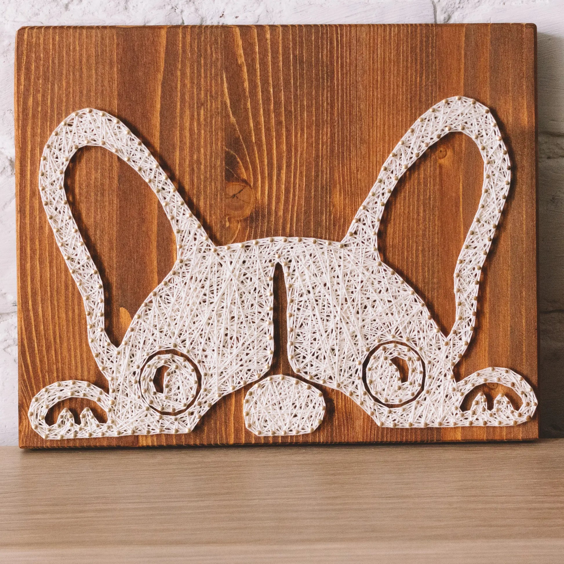 DIY string art kit featuring a cute French Bulldog silhouette outlined with ivory thread on a rustic wooden board by GoodStrings - zoomed front view