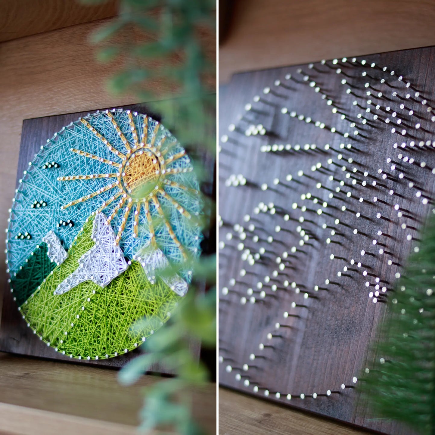 A piece of string art on a wooden board depicting a scenic mountain landscape. The landscape features green mountains with white snow-capped peaks, a bright yellow sun with rays, and a light blue sky with small clouds, all created using colorful strings and silver nails.