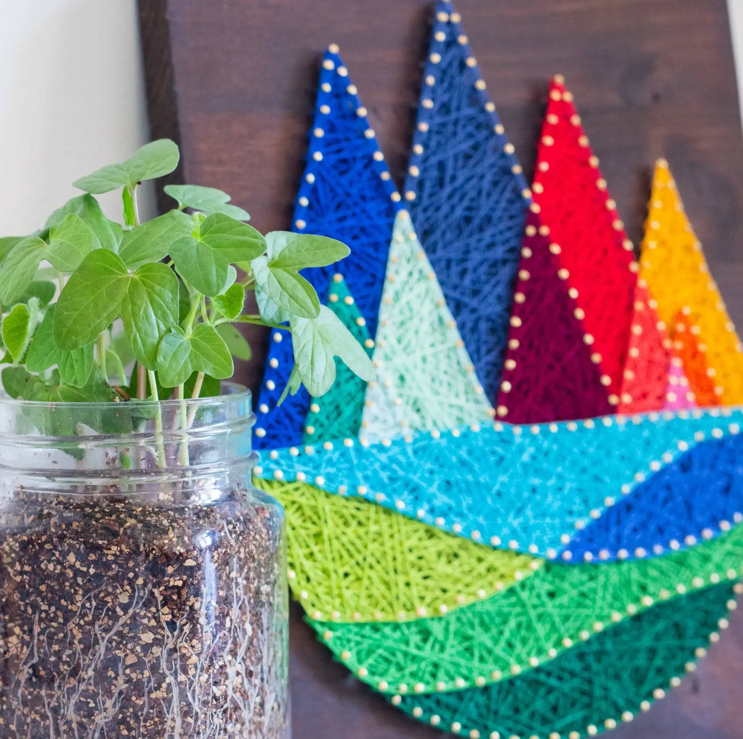 DIY string art kit featuring colorful mountains created with vibrant threads on a dark wooden board by GoodStrings