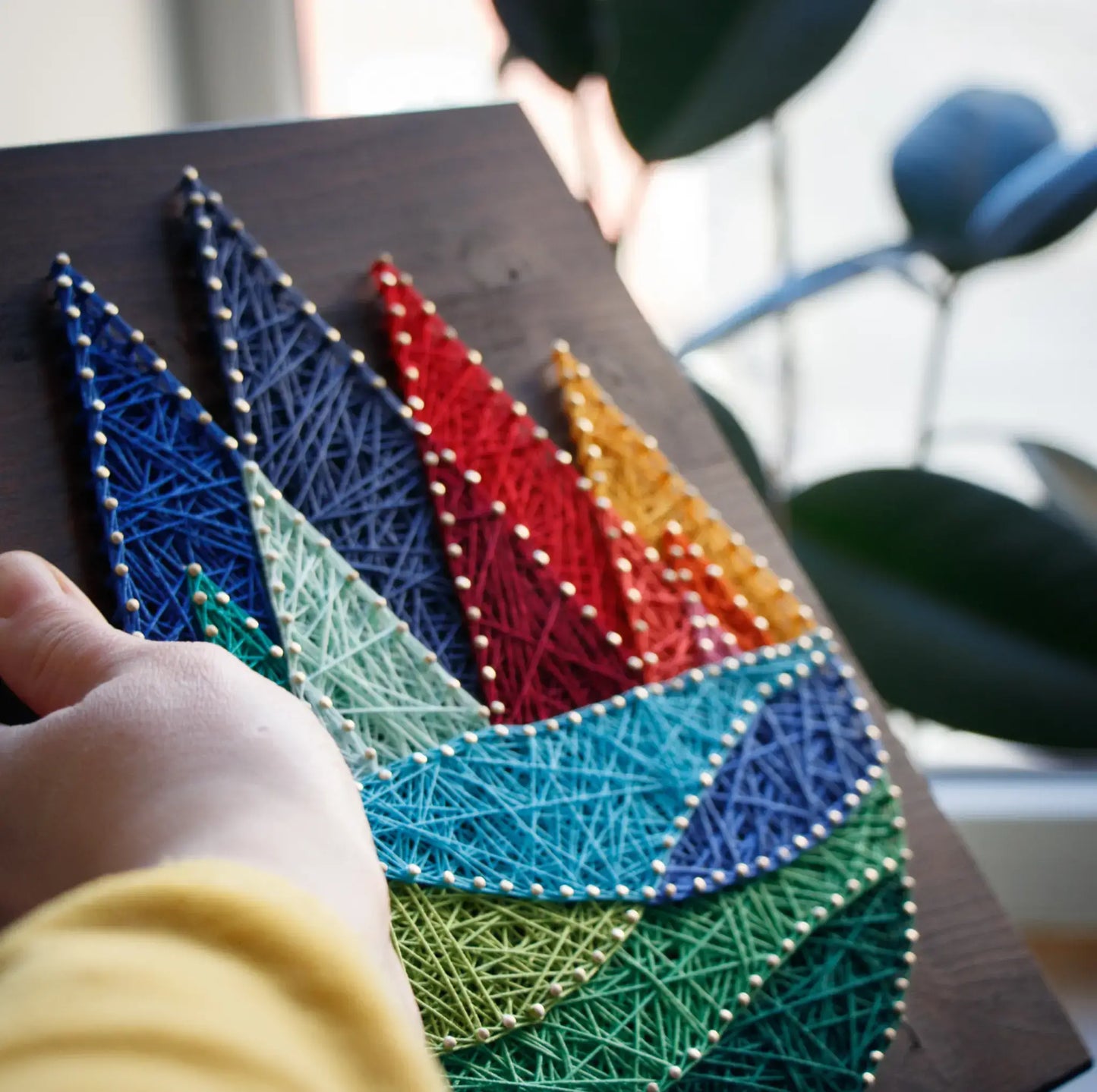 DIY string art kit featuring colorful mountains created with vibrant threads on a dark wooden board by GoodStrings