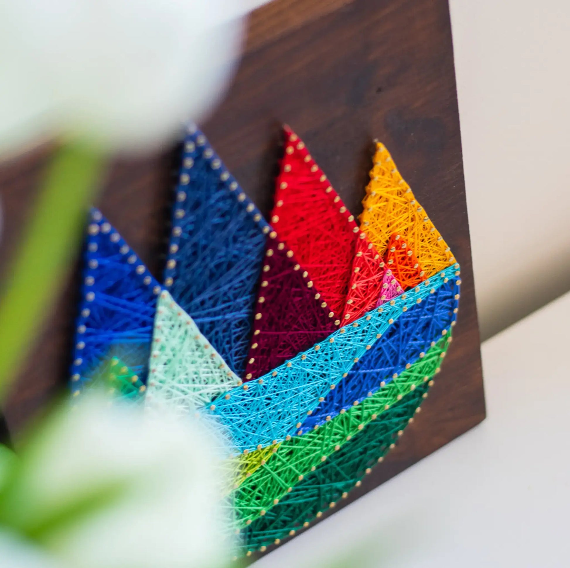 DIY string art kit featuring colorful mountains created with vibrant threads on a dark wooden board by GoodStrings