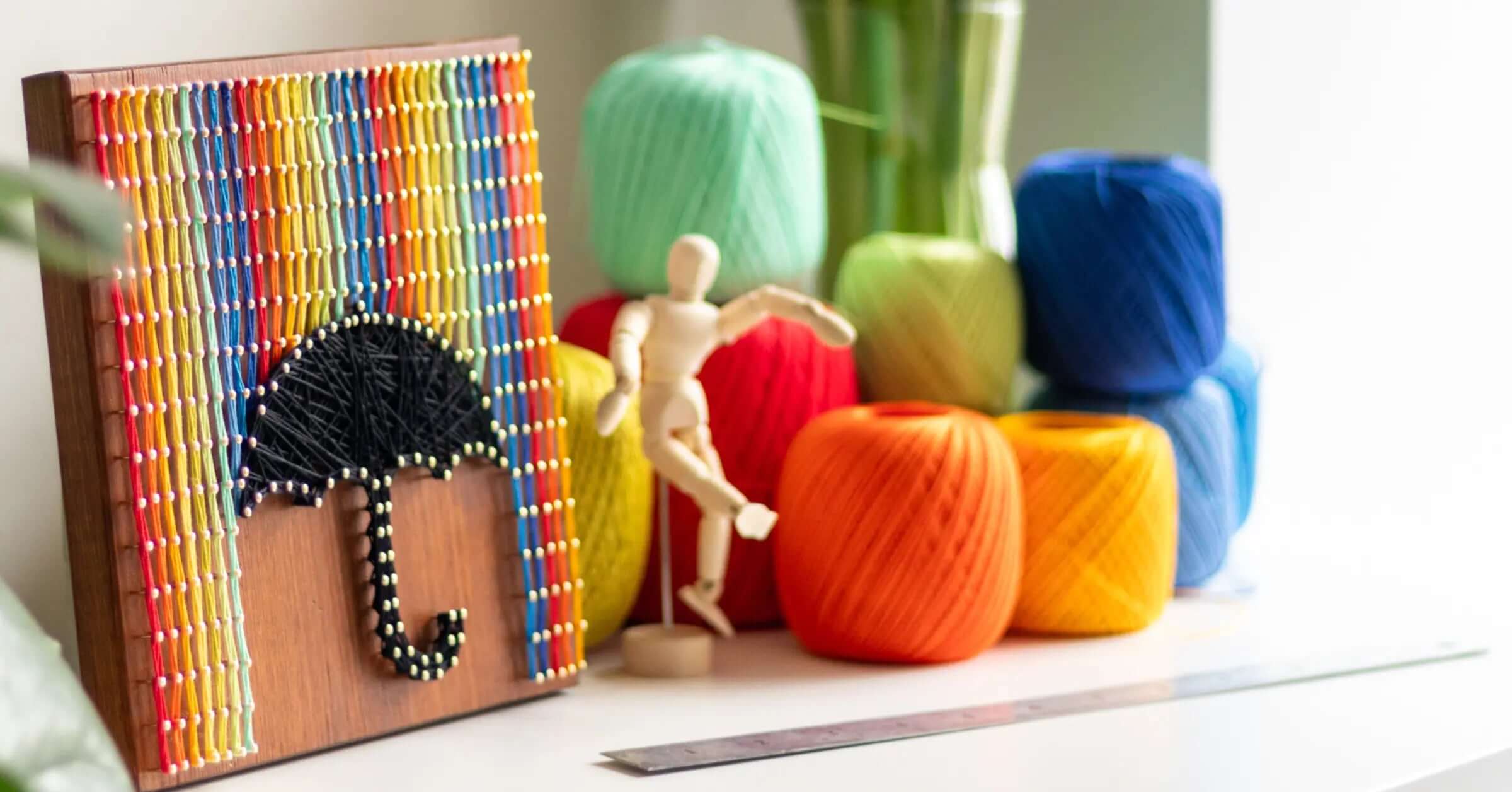 colorful string art wall sign with black umbrella and a lot of colorful threads