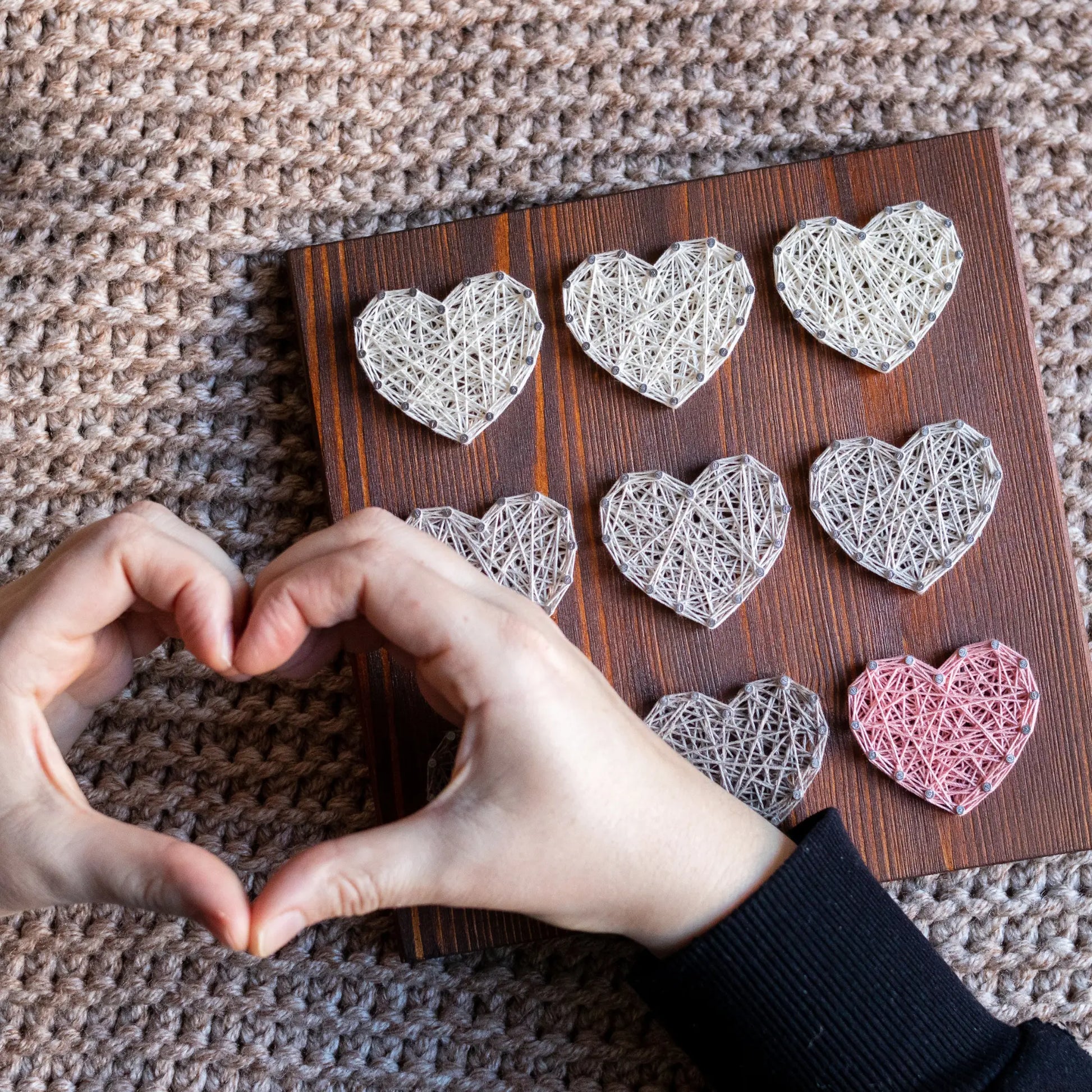 Heart string art pattern design on a wooden board featuring multiple heart shapes. A DIY craft project, perfect for home decor, made using nails and string. Available as a digital download for easy crafting.