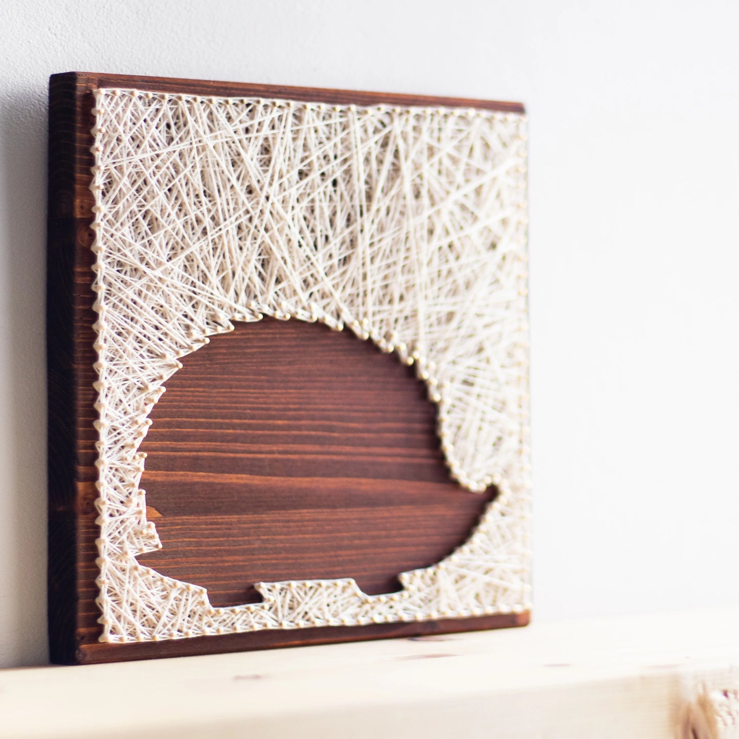 Left side view of Hedgehog silhouette string art sign made from Goodstrings pattern pattern on a wooden base with ivory thread, designed for beginners. Available as a digital download for easy, DIY home decor.