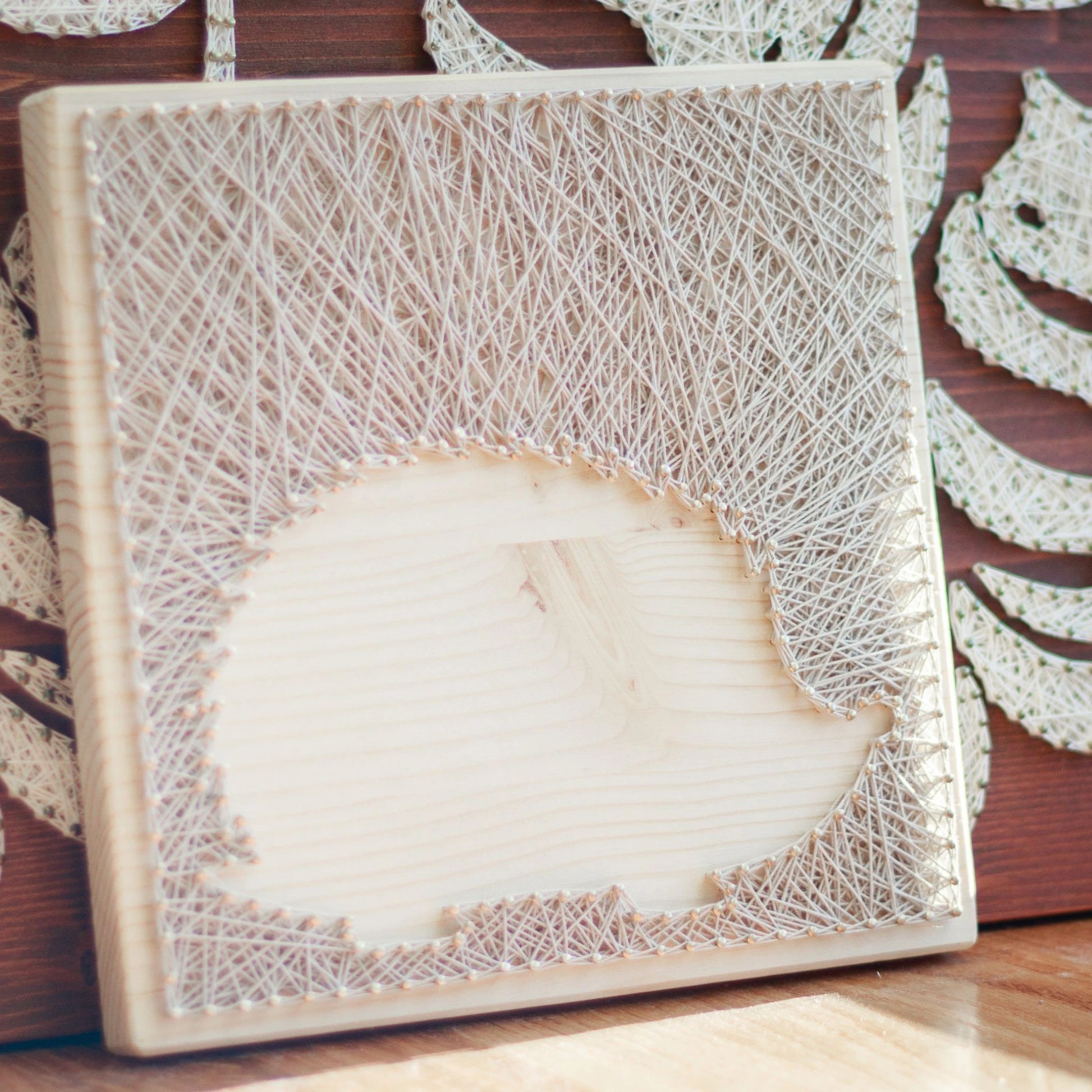 Lifestyle view of hedgehog silhouette string art pattern on a wooden base with ivory thread, designed for beginners. Available as a digital download for easy, DIY home decor.