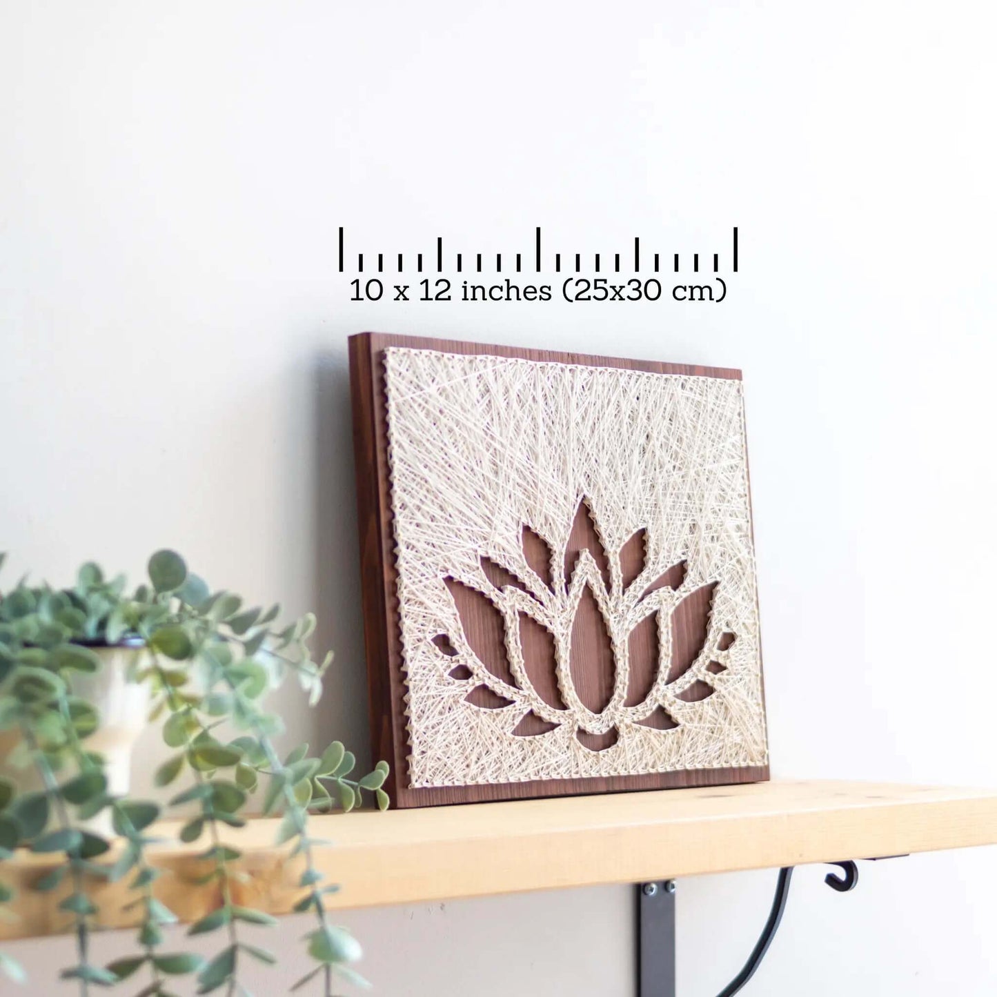 lotus string art sign on a brown wood base