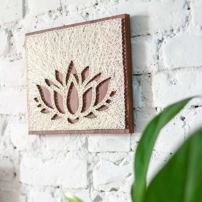 lotus string art sign on a brown wood base