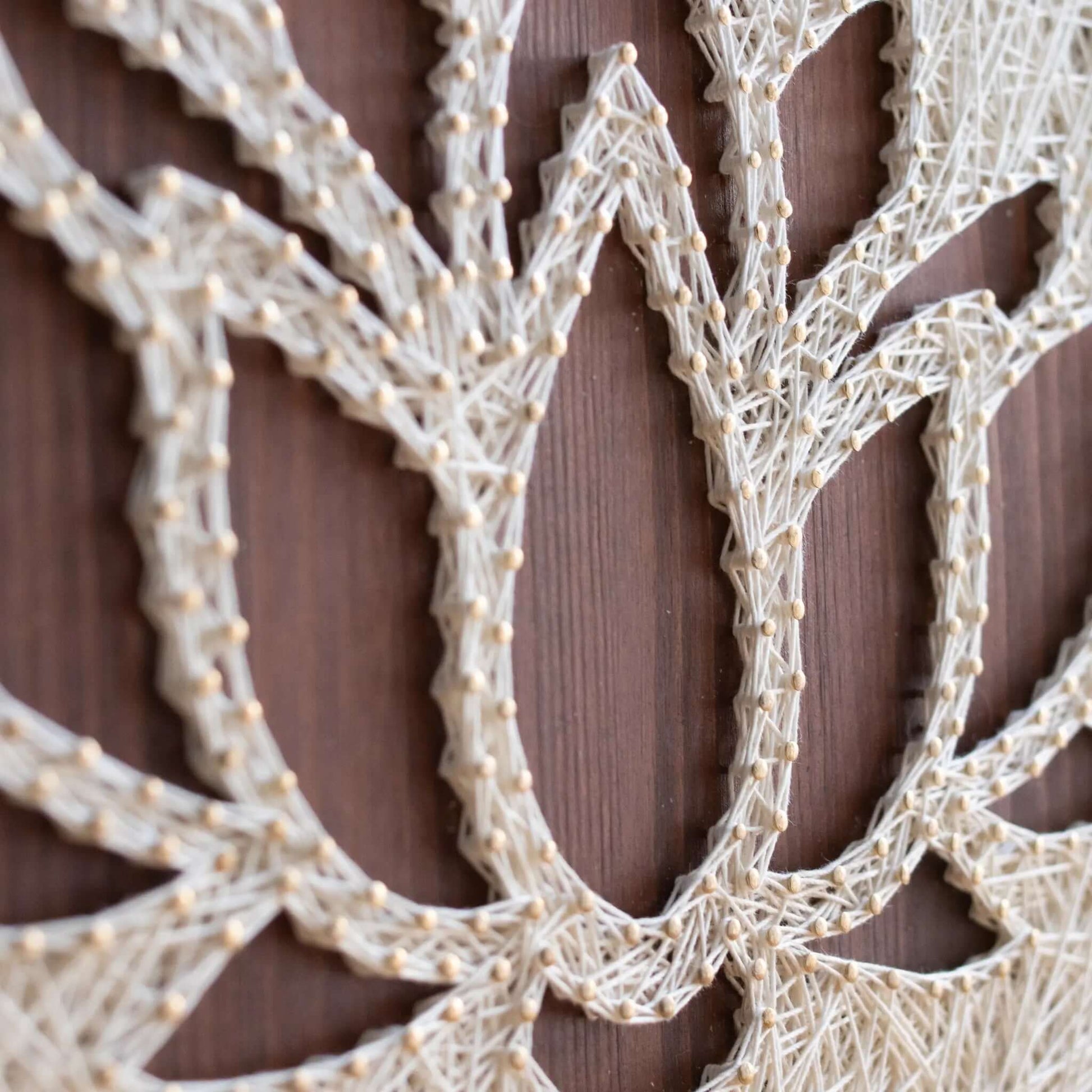 lotus string art sign on a brown wood base