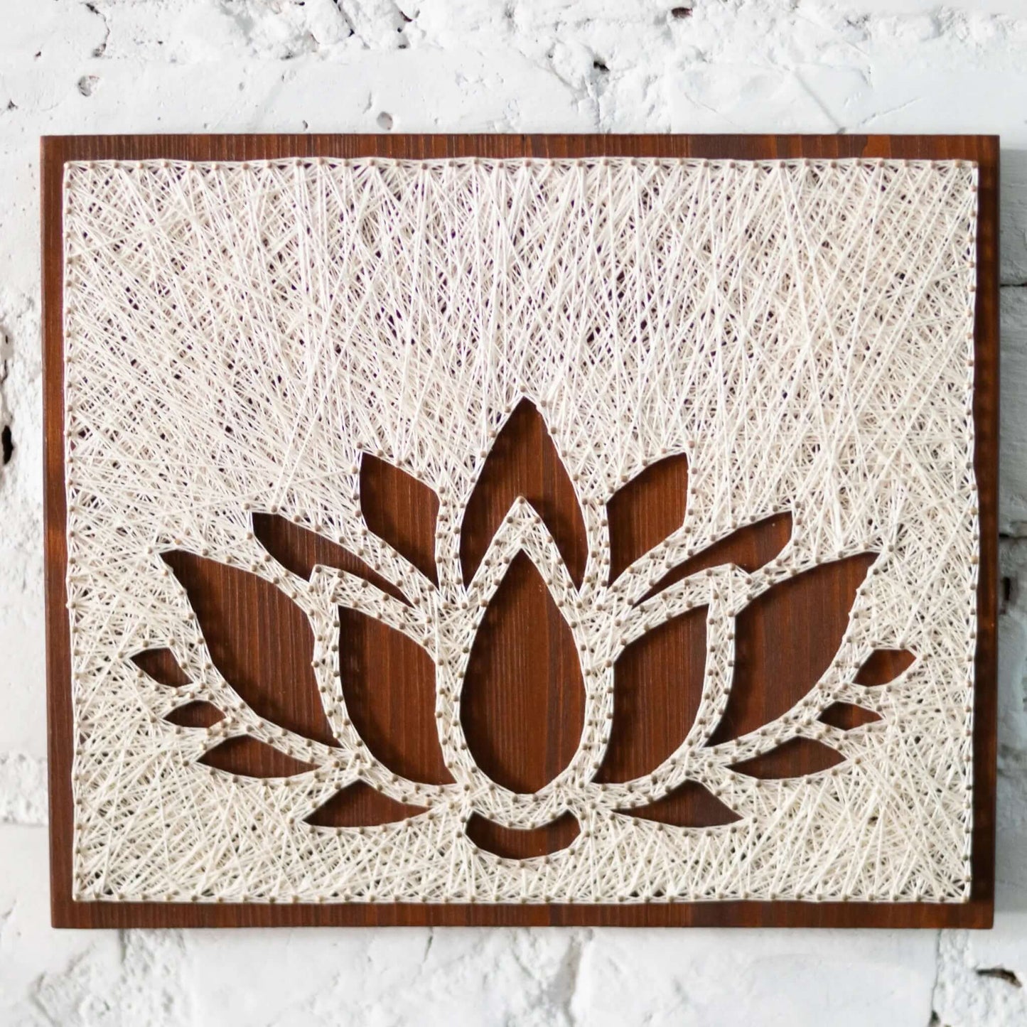 lotus string art sign on a brown wood base