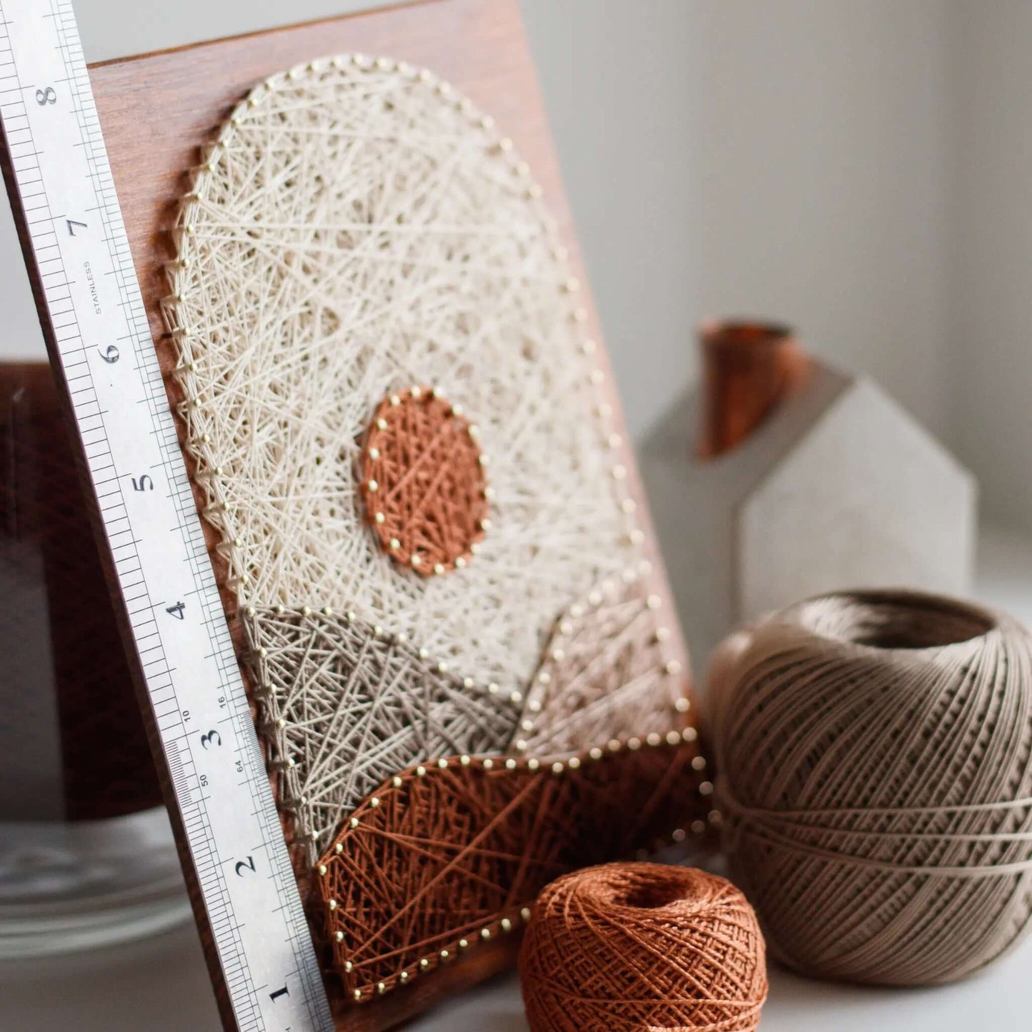 beige mountain string art sign on a brown wood base - finished with ruler for scale