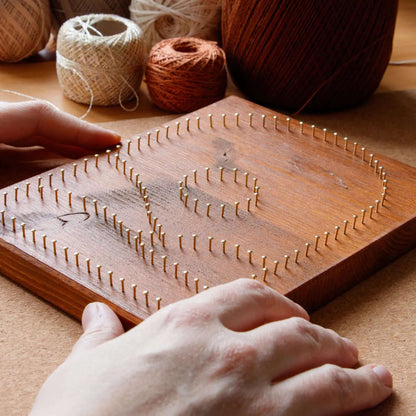 beige mountain string art sign on a brown wood base being made