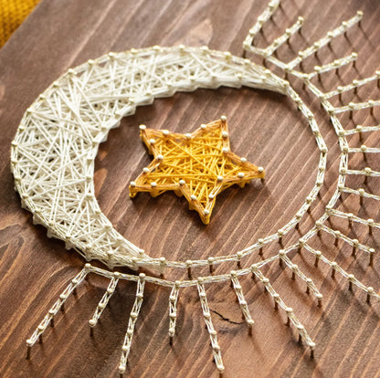 DIY string art kit featuring a crescent moon with a golden star created with threads on a wooden board by GoodStrings