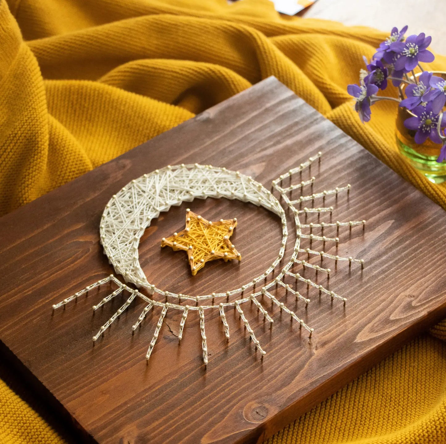 DIY string art kit featuring a crescent moon with a golden star created with threads on a wooden board by GoodStrings