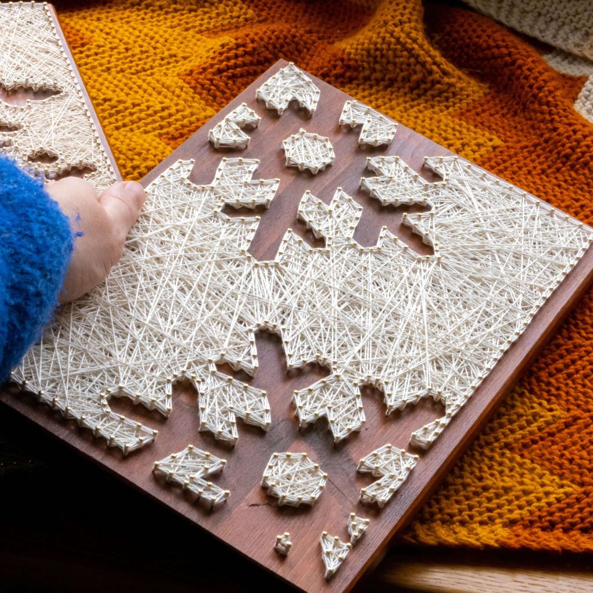 snowflake string art sign on a brown wood base